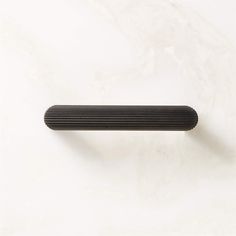 a black piece of wood sitting on top of a white surface