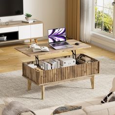 a living room with a couch, coffee table and laptop on top of it in front of a window