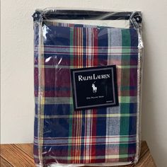 a plaid bag sitting on top of a wooden table