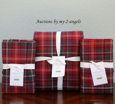 three wrapped presents sitting on top of a wooden table