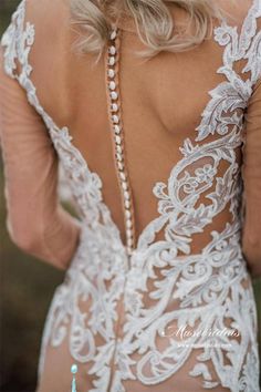 the back of a woman's wedding dress with pearls on her neck and shoulders