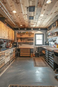 a garage with lots of tools on the wall and wood flooring, including cabinets