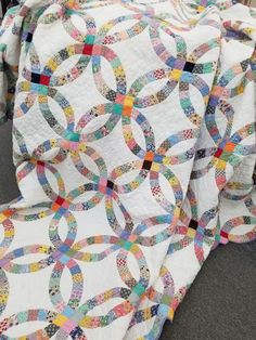 a white quilt with multicolored circles on it