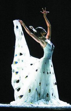 a woman in a white dress is dancing