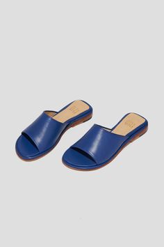 Get ready for the Pileta Slide in Cobalt to be your favorite summer shoe. It's got the ease of a flip-flop but is as finely crafted as any shoe in our collection, which means it's going to be a keeper. Its simple shape and stand-out color will make it easy to combine with a range of textures, fabrications and silhouettes in your summer wardrobe. Who it's for: The woman who loves a pop of color. Kidskin upper with vegetable tanned leather lining and a 25 mm stacked leather heel and sole. Handmade in Argentina. Blue Textured Sole Sandals With Open Toe, Blue Textured Sole Open Toe Sandals, Blue Open Toe Sandals With Textured Sole, Blue Summer Flip Flops With Ortholite Insole, Blue Ortholite Insole Flip Flops For Summer, Blue Flip Flops With Ortholite Insole For Summer, Modern Blue Summer Mules, Modern Blue Mules For Summer, Blue Sandals With Flat Leather Sole