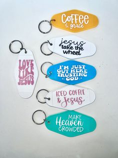 six key chains with different sayings are shown on a white surface, including coffee and jesus