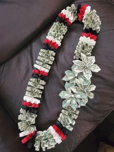 dollar bill origami christmas wreath made out of money on a black leather couch