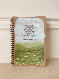 a spiral notebook with a painting on it