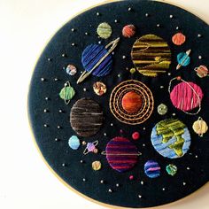 an embroidery project with different types of planets on it's black circular surface,