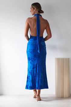 a woman in a blue dress looking back