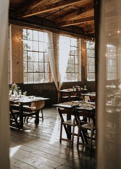 the inside of a restaurant with tables and chairs set up in front of large windows