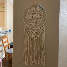 a white wall hanging on the side of a building next to a dining room table