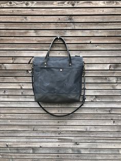 Black canvas leather tote bag made for daily use to take with you everywhere, also the office, smart enough for any occasion The bag is constructed out of heavy weight waxed canvas in black with a bottom in leather, closing with a zipper. There is an outside pocket with rounded edges closing with a snap on one side Handles and cross body strap are made in vegetable tanned leather. Inside the bag is lined with cotton canvas with a padded laptop compartment and on the other side a double slip pock Everyday Satchel With Waxed Finish And Double Handle, Waxed Canvas Satchel With Leather Handles For On-the-go, Everyday Waxed Canvas Satchel With Leather Handles, Everyday Leather Satchel Diaper Bag, Everyday Waxed Canvas Satchel With Double Handle, Leather Tote Diaper Bag For Daily Use, Waxed Canvas Tote Weekender Bag For Everyday Use, Waxed Canvas Tote Weekender Bag For Daily Use, Leather Tote Diaper Bag For Everyday Use