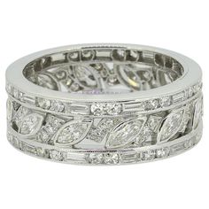 a wedding ring with leaves and diamonds on the sides, set in white gold or silver