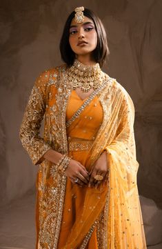 Indian Wedding Dress in Open Jacket and Trouser Style is an embellished attire adorned with hand-crafted embellishments. Premium quality fabric and stylish design of this Indian Dress make it an epitome of beauty and luxury, giving a head-turning look to this attire. Blouse and Jacket: The blouse has an alluring mustard shade and it comes in premium raw silk fabric. The blouse is paired with an embellished Open jacket. The Jacket is fully adorned with embroidery and hand-crafted details of sequi Ceremonial Gown With Intricate Embroidery, Traditional Formal Lehenga With Pearl Embroidery, Traditional Hand Embellished Lehenga For Ceremony, Hand Embellished Gown For Ceremony With Traditional Drape, Hand Embellished Floor-length Sets For Ceremony, Ceremonial Gown With Pearl Embroidery, Anarkali Ceremony Sets Hand Embellished, Elegant Embellished Lehenga For Ceremony, Fitted Hand Embellished Sets For Ceremony