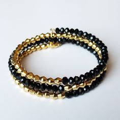 "This black and gold wrap bracelet is a complete look without any effort.  The black faceted rondelles and gold metal bicone beads make this a simply elegant addition to any outfit. This piece can accommodate many wrist sizes, (comfortably, up to a 7.75\" diameter wrist) as the bracelet expands when required.  The bracelet is made with steel wire (nickel-free), metal beads, and glass beads. * * * Care * * * - Handle and store jewelry and accessories gently. - Do not expose jewelry to water or le Gold Stretch Bracelet With Faceted Beads For Party, Gold Crystal Bracelet With Round Black Beads, White Beads Bracelet, Stack Bracelet, Black Beaded Bracelets, Bracelet Metal, Purple Bracelet, Gold Wrap, Rainbow Bracelet