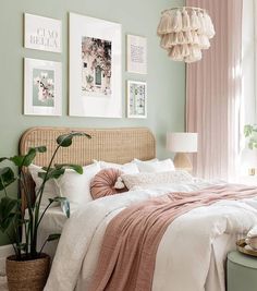 a bedroom with green walls and pictures on the wall above the bed, along with a wicker headboard