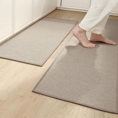 a person standing on the floor in front of two rugs