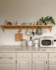 a kitchen with white cabinets and shelves filled with dishes