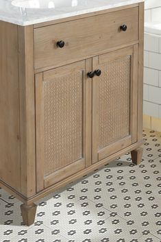 a bathroom vanity with two drawers and a white sink in front of a tiled floor