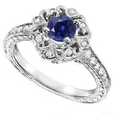 a blue and white diamond ring with filigrees on the band, set in 18k white gold