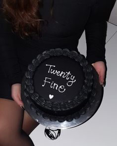 a woman holding a cake with the words twenty fine written on it, in front of her