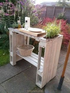 a potted planter sitting on top of a wooden table next to a garden