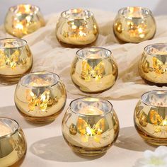 there are many small glass candles in the shape of butterfly's and butterflies on them