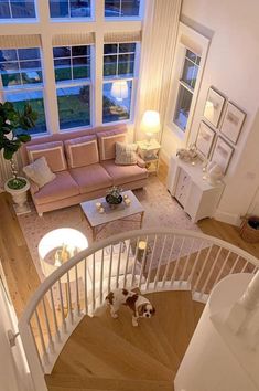 a living room filled with furniture and a spiral stair case next to a large window