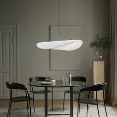 a dining room table with chairs and a hanging light