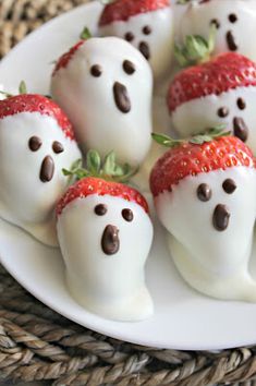 chocolate covered strawberries are arranged in the shape of ghost faces on a white plate