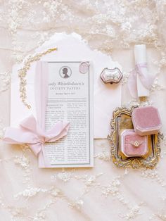 the wedding suite is laid out on top of a white tablecloth with pink accessories