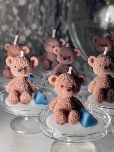 small teddy bears sitting on top of each other in plastic cups with blue hearts attached to them