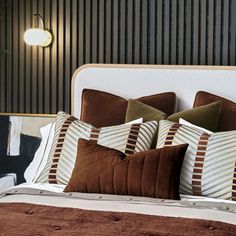 a neatly made bed with brown and white pillows