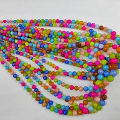 multicolored beads are arranged on a white surface