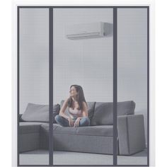 a woman sitting on top of a gray couch