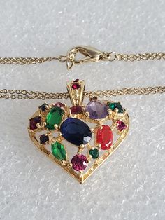 "If you are searching for the perfect Valentine's Day gift than you come to the right place. Presented here is a multi-colored glass heart pendant necklace that is strung onto a double curb chain. Both pieces are made in a gold tone base metal with no hallmark. The heart pendant has an open back where you can see the colored stones. The bale also has 2 small red stones and is big enough for any type of chain. Both pieces are vintage and are in excellent condition and will arrive in a gift box wi Multicolor Heart Cut Jewelry For Valentine's Day, Multicolor Heart Charm Jewelry For Mother's Day, Multicolor Heart Necklace For Valentine's Day Gift, Multicolor Heart Pendant Jewelry For Mother's Day, Multicolor Jewelry For Valentine's Day Party, Colorful Pendant Jewelry As A Gift, Multicolor Pendant Necklace For Birthday, Valentine's Day Multicolor Pendant Jewelry, Vintage Heart Pendant Necklace For Party