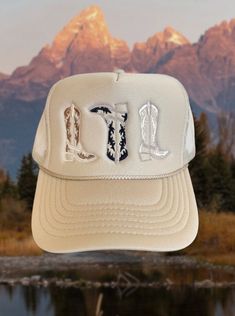 Tan trucker hat with 3 embroidered cowboy boots in the perfect neural fall colors One size fits most due to adjustable snap closure. Breathable mesh back. Trucker Hats Western, Fall Outdoor Baseball Cap, Western Snapback Trucker Hat For Ranch, Western Snapback Hat With Flat Brim, Fitted Trucker Hat With Curved Brim For Outdoor, Western Flat Brim Baseball Cap For Rodeo, Trucker Baseball Cap For Country Events, Western Style Brown Trucker Hat For Outdoor, Western Snapback Hat For Ranch