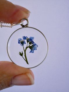 "Our Arrowhead Frame has a modern bohemian feel and is available in a variety of real preserved botanicals. Choose from 24k gold plated or .999 sterling silver plated. The Dandelion Seed symbolizes wishes. The Fern is a symbol of sincerity Forget-me-nots are known as a symbol of lasting friendship, love, and remembrance Lavender is a symbol of devotion Pendant hangs from a gold or silver plated chain, available in 26\" or 30\" lengths. Choose from plain chain or satellite chain, see picture for Delicate Flower Birth Flower Jewelry, Minimalist Birth Flower Jewelry Keepsake, Dainty Birth Flower Round Pendant Jewelry, Blue Sterling Silver Birth Flower Jewelry, Blue Sterling Silver Jewelry With Birth Flower, Botanical Sterling Silver Jewelry Gift, Keepsake Jewelry Round Pendant With Natural Inclusions, Gold Sterling Silver Necklace With Pressed Flowers, Gold Sterling Silver Necklaces With Pressed Flowers