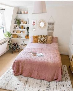 a bedroom with a pink bed and white walls