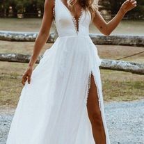 a woman in a white dress is holding her hand out to the side while standing outside