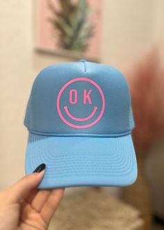 When you are running behind because your little one isn't cooperating with your schedule, we've got you! You can still go out and about in style with this OK smiley trucker hat! Hats My Madi Blue With Pink Made in Oklahoma Blue Fun Style Snapback Hat, Fun Blue Snapback Baseball Cap, Fun Blue Adjustable Snapback Hat, Fun Blue Trucker Hat, Fun Blue Snapback Hat, Fun Snapback Hat With Curved Bill, Fun Snapback Trucker Hat For Sports, Fun Sports Snapback Trucker Hat, Fun Blue Adjustable Trucker Hat