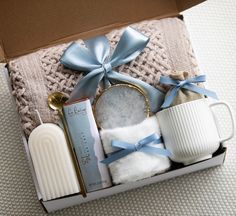 an open box with some items in it on a table next to a cup and spoon