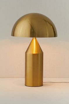 a gold lamp sitting on top of a white table