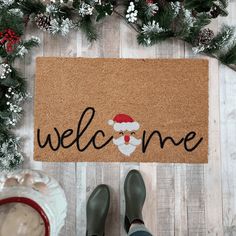 someone standing in front of a welcome mat with the word welcome on it and a santa hat