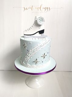 there is a cake that has ice skates on top of it and snow flakes