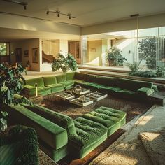 a living room filled with lots of green couches next to a large window covered in plants