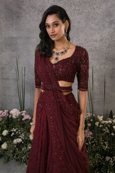 Rosewood organza silk lehenga with thread, sequins, cutdana, and crystals embroidery. Comes with a net blouse, a dupatta, and a belt.
Component: 4
Pattern: Embroidered
Type Of Work: Thread, Sequins, Cutdana, Crystals
Neckline: V Neck
Sleeve Type: Half
Fabric: Lehenga : Organza silk, Blouse and Dupatta : Net, Lining : Shantoon
Color: Maroon
Other Details: 
Closure : Zip on the side for lehenga and hooks at the back for blouse.
Occasion: Wedding, Bride - Aza Fashions