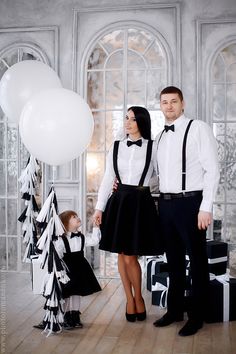 a man and woman standing next to each other with balloons in the air behind them