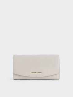 Oozing ultimate chic vibes with the light grey hue, this long wallet demonstrates just how fashion meets functionality. Boasting a modern curved front flap, this gem secures shut with a snap-button closure, keeping all your items safe and within reach. Carry it as a mini clutch with a woven tunic dress and stiletto heels for a casual weekend look. Complete your ensemble with a pair of butterfly sunglasses to ace your fashion game. Luxury White Wallets For Formal Occasion, Luxury Modern Rectangular Wallets, Handmade White Wallets, Luxury Modern Formal Wallets, Chic Wallets With Magnetic Closure For Everyday Use, Chic Everyday Wallet With Magnetic Closure, Chic Everyday Wallets With Magnetic Closure, Modern Trifold Wallet For Evening, Elegant Gray Bifold Wallet